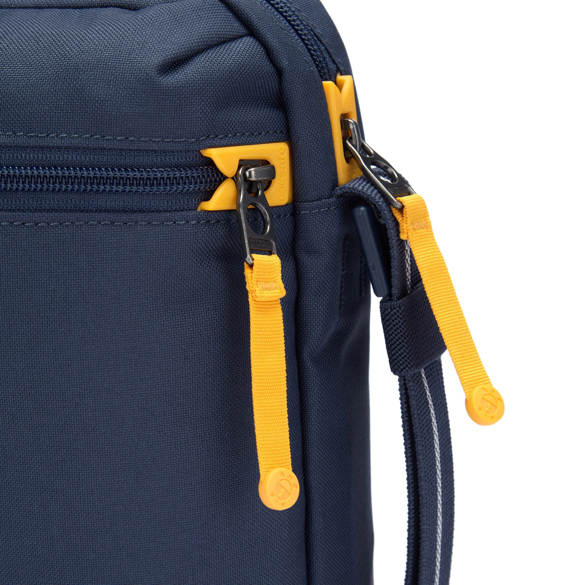 Close up of yellow zipper pulls and lockable zippers on the coastal blue Pacsafe® GO Anti-Theft Festival Crossbody