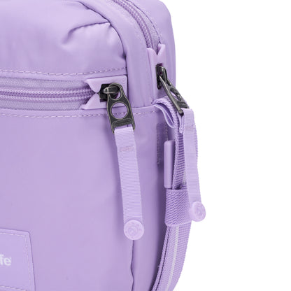 Close-up of the Pacsafe® GO Anti-Theft Micro Crossbody in lavender with dual zippers and fabric pull tabs.