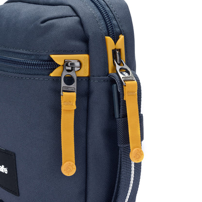 Close-up of the Pacsafe® GO Anti-Theft Micro Crossbody in blue with yellow zippers, made from recycled polyester.