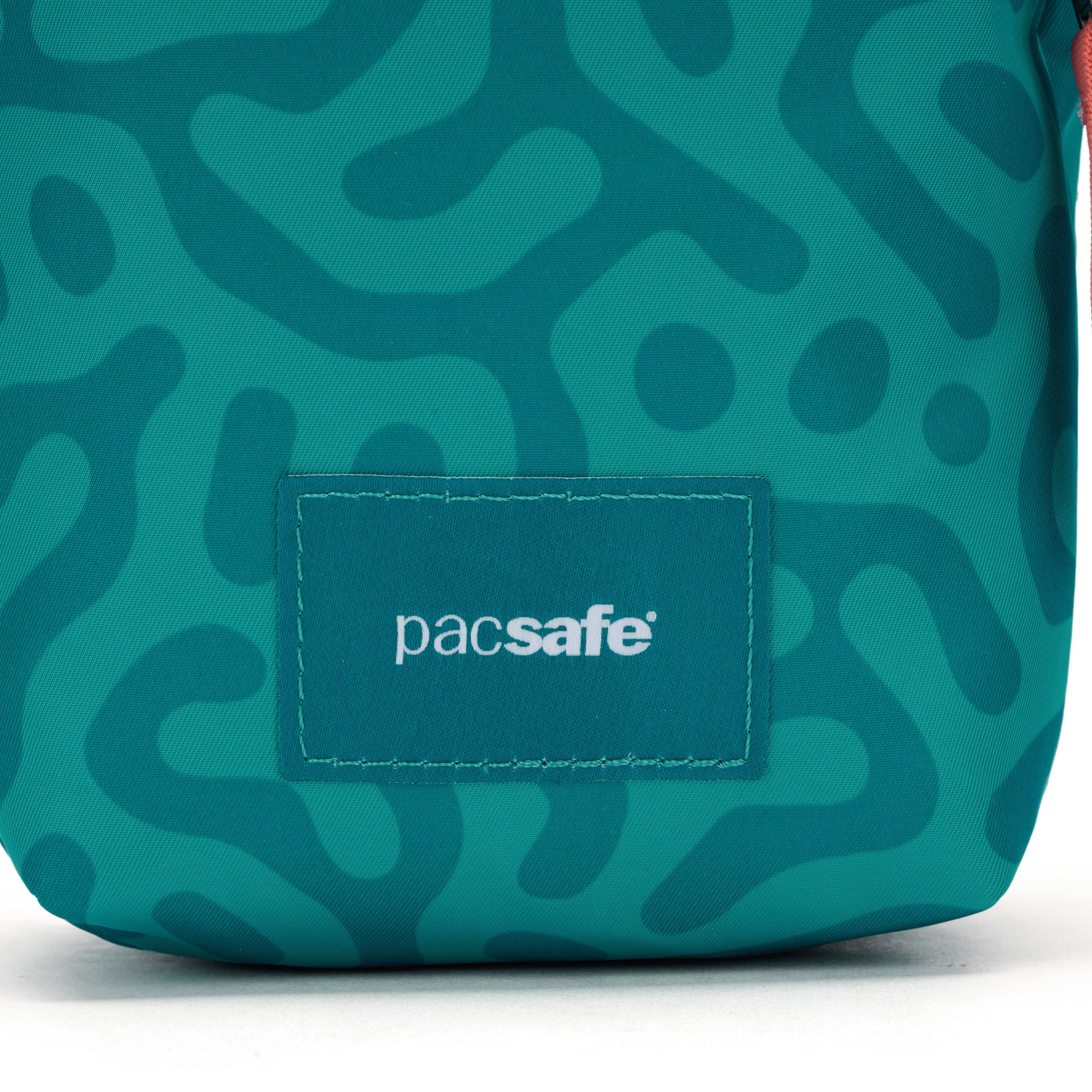 Pacsafe® GO Anti-Theft Micro Crossbody in teal recycled polyester with wavy pattern and RFID pocket.