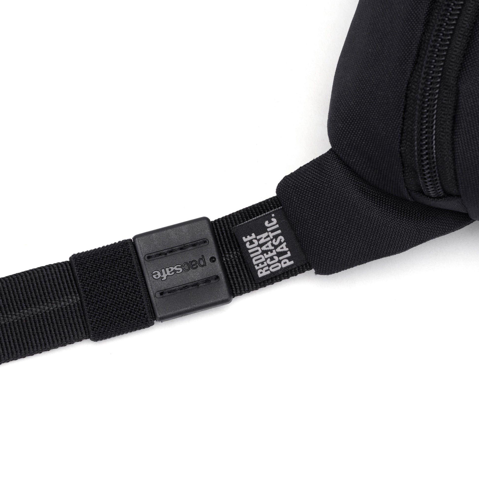Close-up of the Pacsafe® GO Anti-Theft Micro Sling's black strap with plastic buckle, made from recycled polyester.