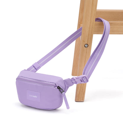 The Pacsafe® GO Anti-Theft Micro Sling by Pacsafe hangs on a wooden chair leg.