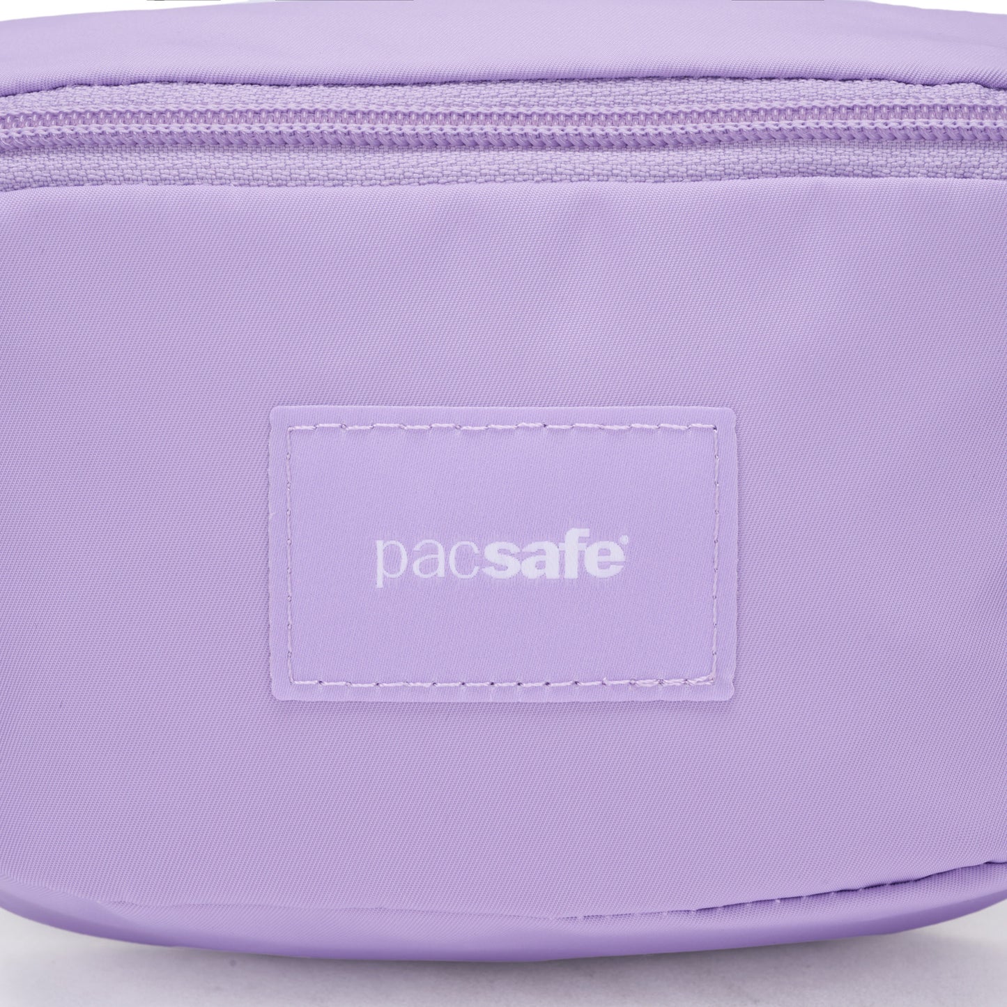 Close-up of a light purple Pacsafe® GO Anti-Theft Micro Sling pouch with zipper and stitched brand label.