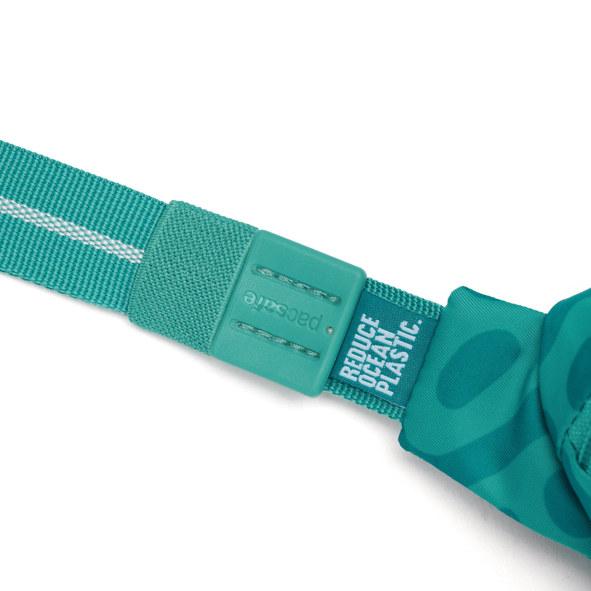 Close-up of teal buckle on Pacsafe® GO Anti-Theft Micro Sling, made with recycled polyester.