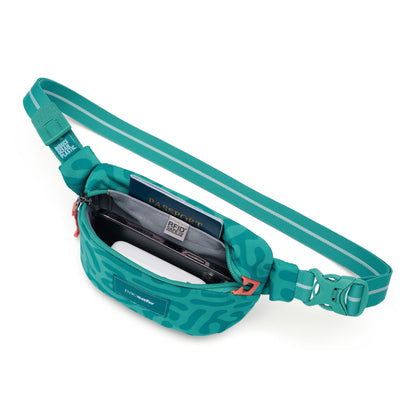 The Pacsafe® GO Anti-Theft Micro Sling by Pacsafe in teal fits a passport and phone in its open main compartment.