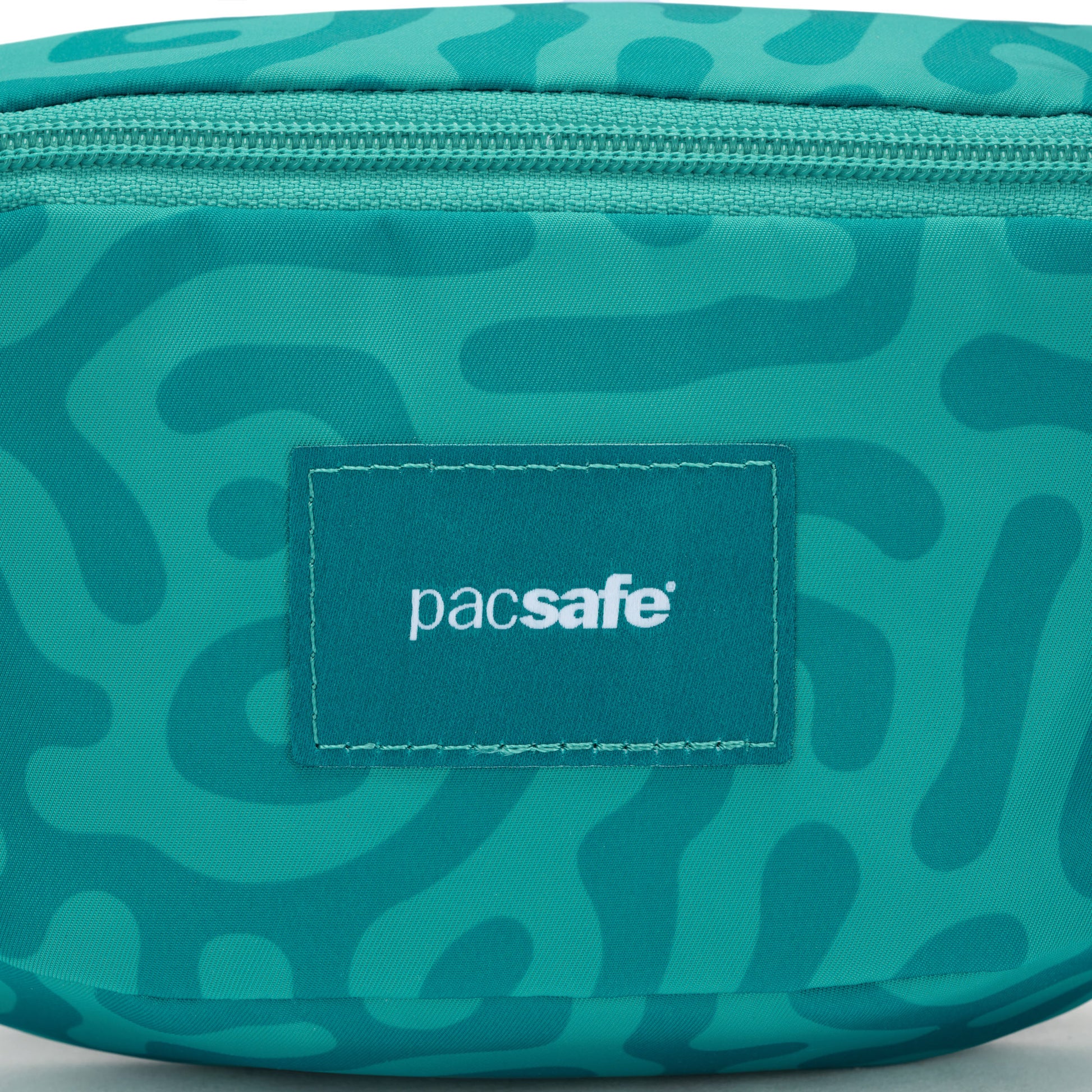 Teal Pacsafe® GO Anti-Theft Micro Sling with abstract pattern and front logo.