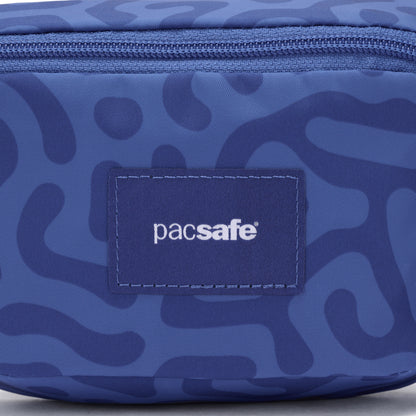 Close-up of the blue Pacsafe® GO Anti-Theft Micro Sling with abstract pattern, recycled polyester, and logo patch.