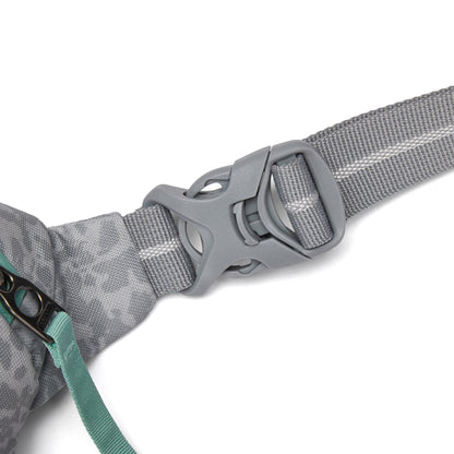 Close-up of Pacsafe® GO Anti-Theft Micro Sling gray buckle on strap, with teal zipper and fabric detail.
