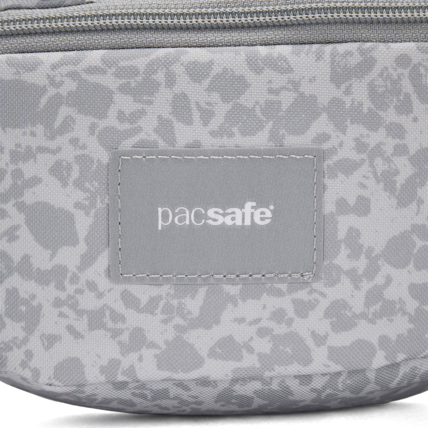 Close-up of the Pacsafe® GO Anti-Theft Micro Sling in gray with logo patch and top zipper.