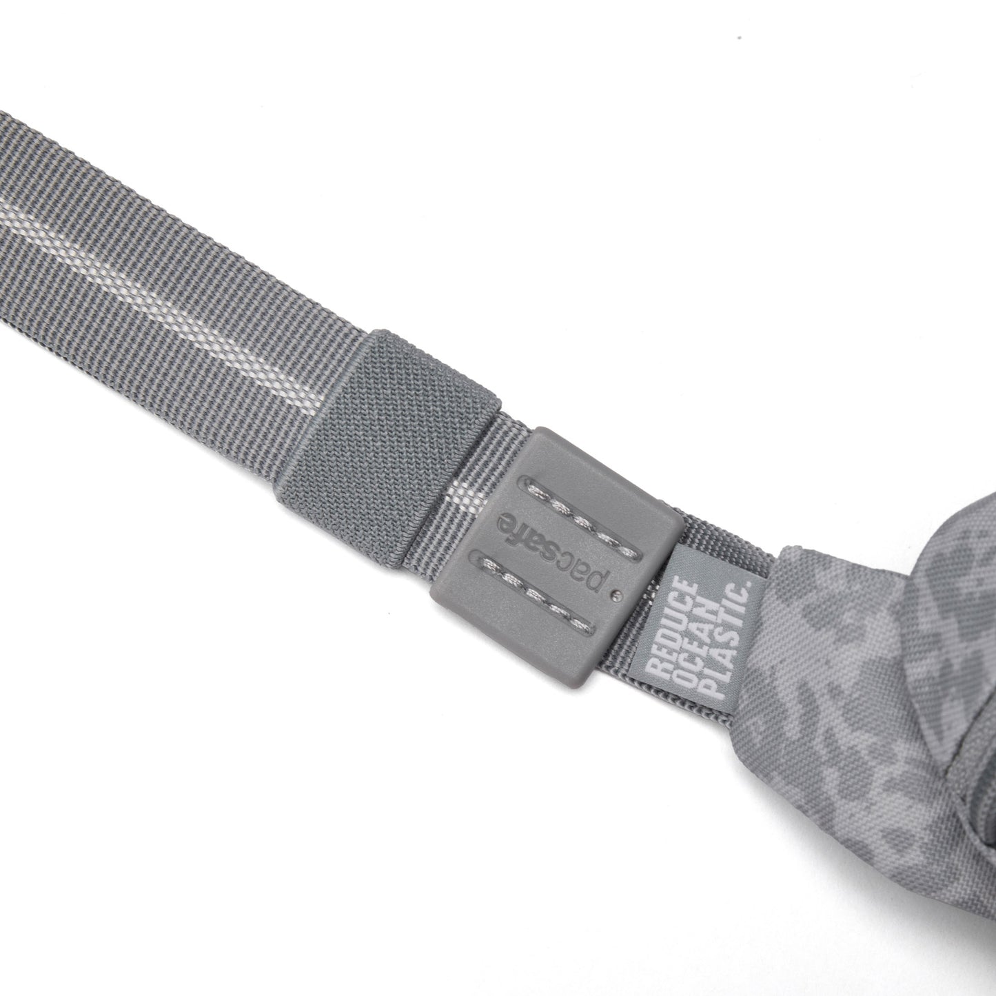 Close-up of Pacsafe® GO Anti-Theft Micro Sling’s gray recycled strap with plastic buckle and printed text.