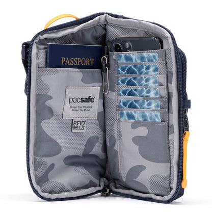 Pacsafe® GO Anti-Theft Tech Crossbody in coastal blue colour unzipped showing interior pockets that includes a RFID blocking pocket, mobile phone, passport and credit card pockets.