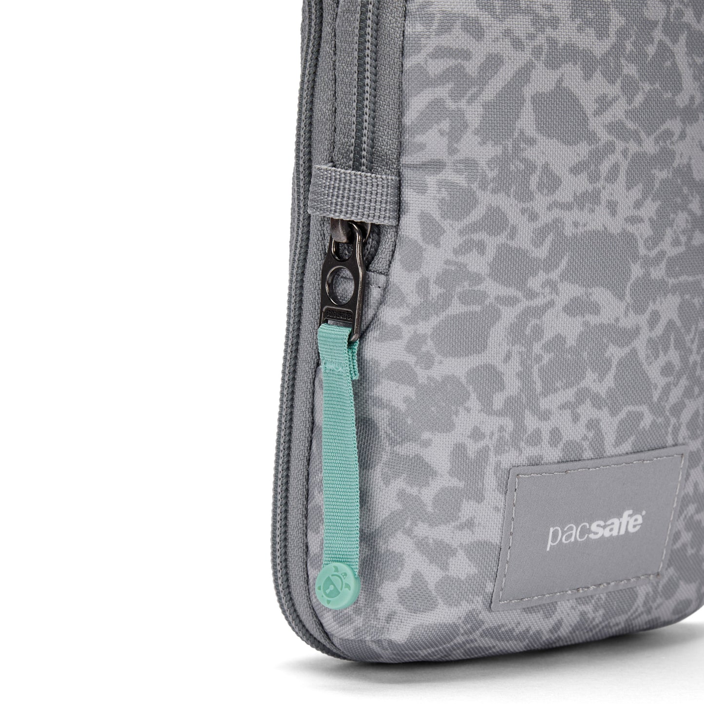 Close-up of the Pacsafe® GO Anti-Theft Tech Crossbody with teal zipper pull and subtle patterned gray fabric.