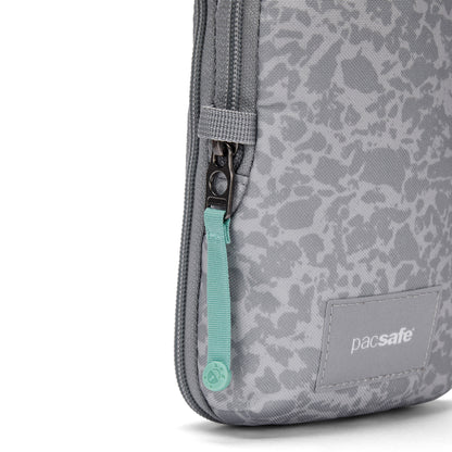 Close-up of the Pacsafe® GO Anti-Theft Tech Crossbody with teal zipper pull and subtle patterned gray fabric.