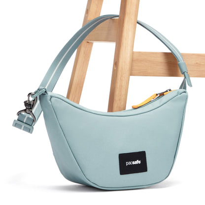 Pacsafe® GO Anti-Theft Lunar Crossbody, fresh mint, with strap attached to chair leg