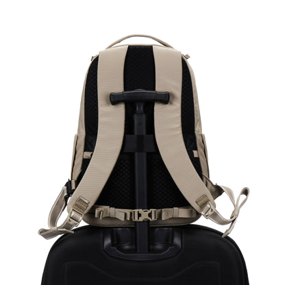 Pacsafe® V 16L Anti-theft All-Around Backpack in beige, secured on a suitcase handle, rear view.