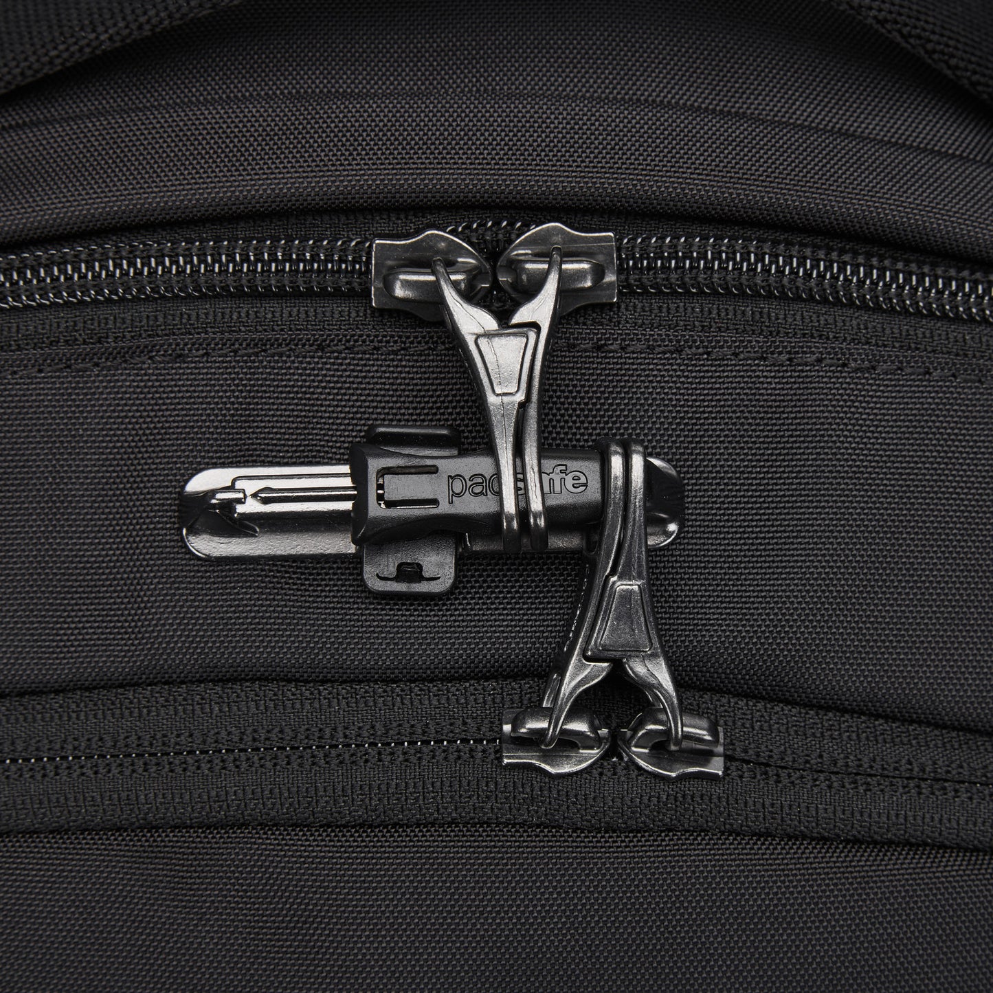 Close-up of dual black zippers on the Pacsafe® V 20L Anti-theft City Backpack made of recycled polyester.