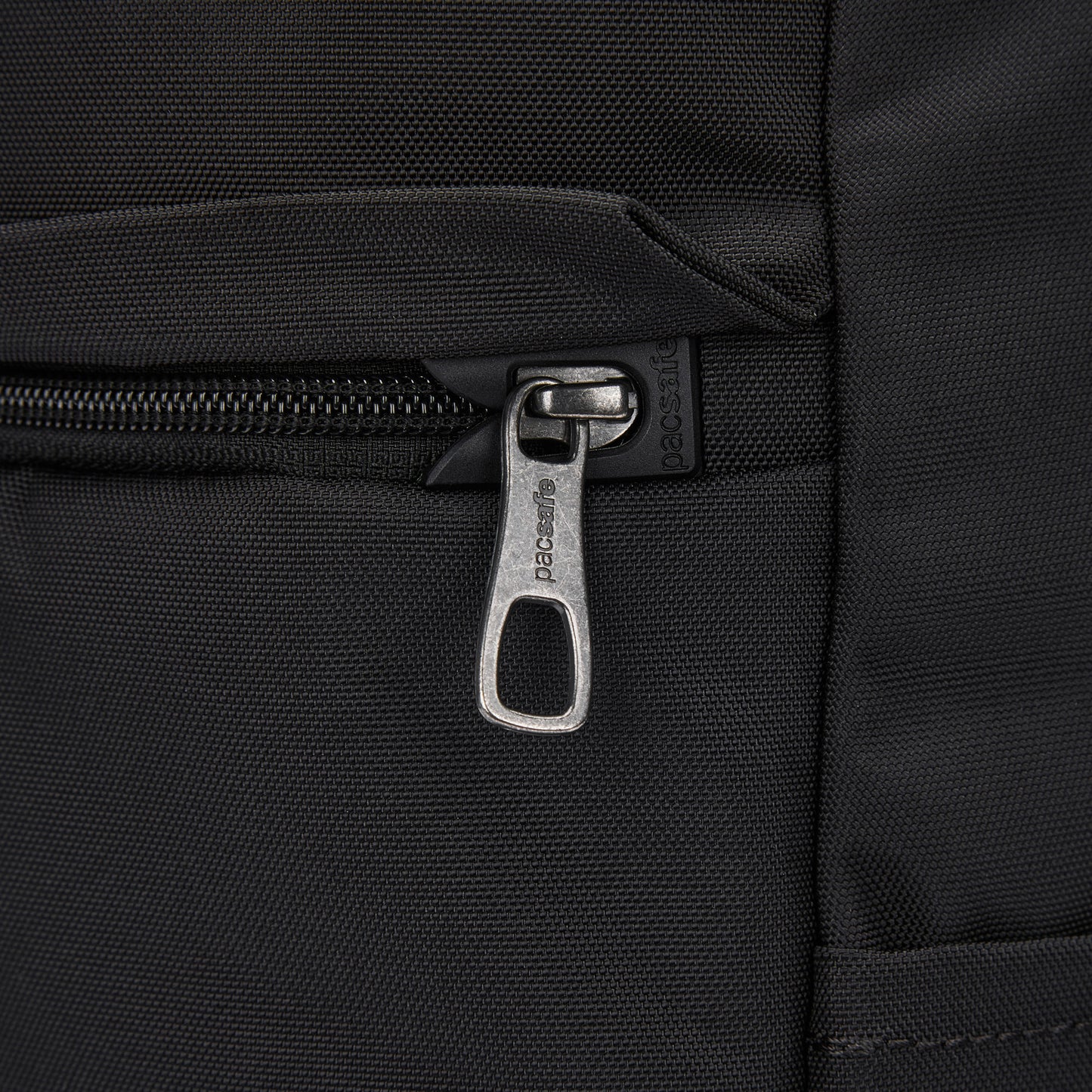 Close-up of the Pacsafe® V 20L Anti-theft City Backpack in black recycled polyester with a metal zipper.