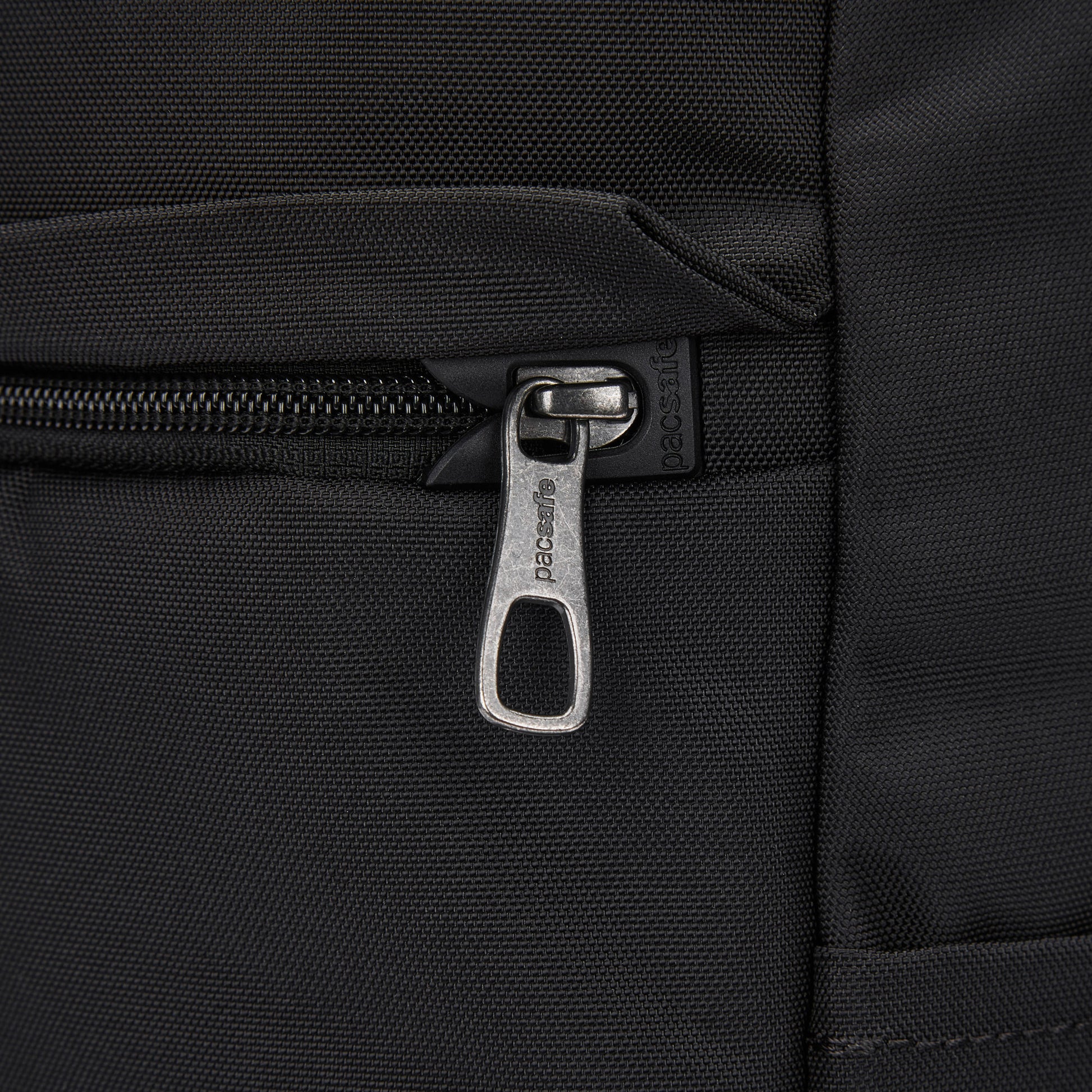 Close-up of the Pacsafe® V 20L Anti-theft City Backpack in black recycled polyester with a metal zipper.