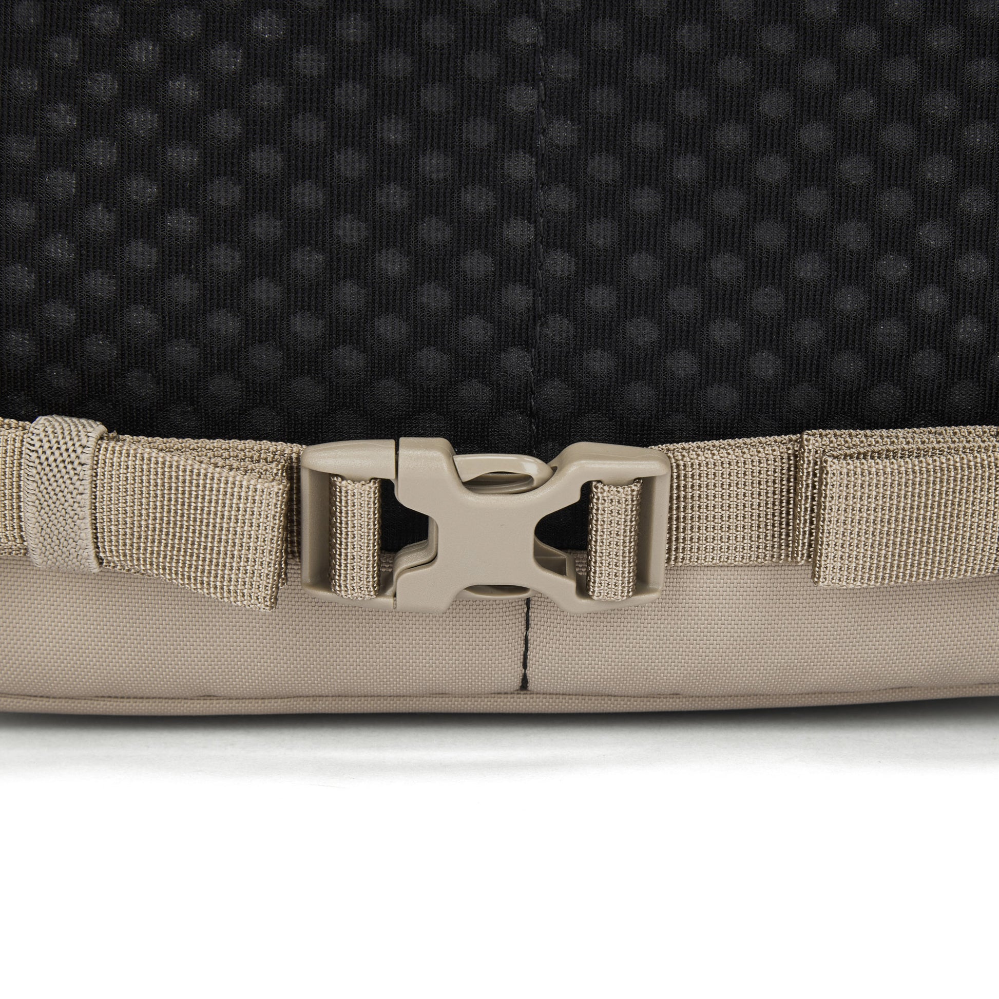 Close-up of a beige plastic buckle on the Pacsafe® V 20L Anti-theft City Backpack by Pacsafe.