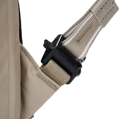 Close-up of Pacsafe buckle on beige strap of the Pacsafe® V 26L Anti-theft Tour Backpack's tan fabric.