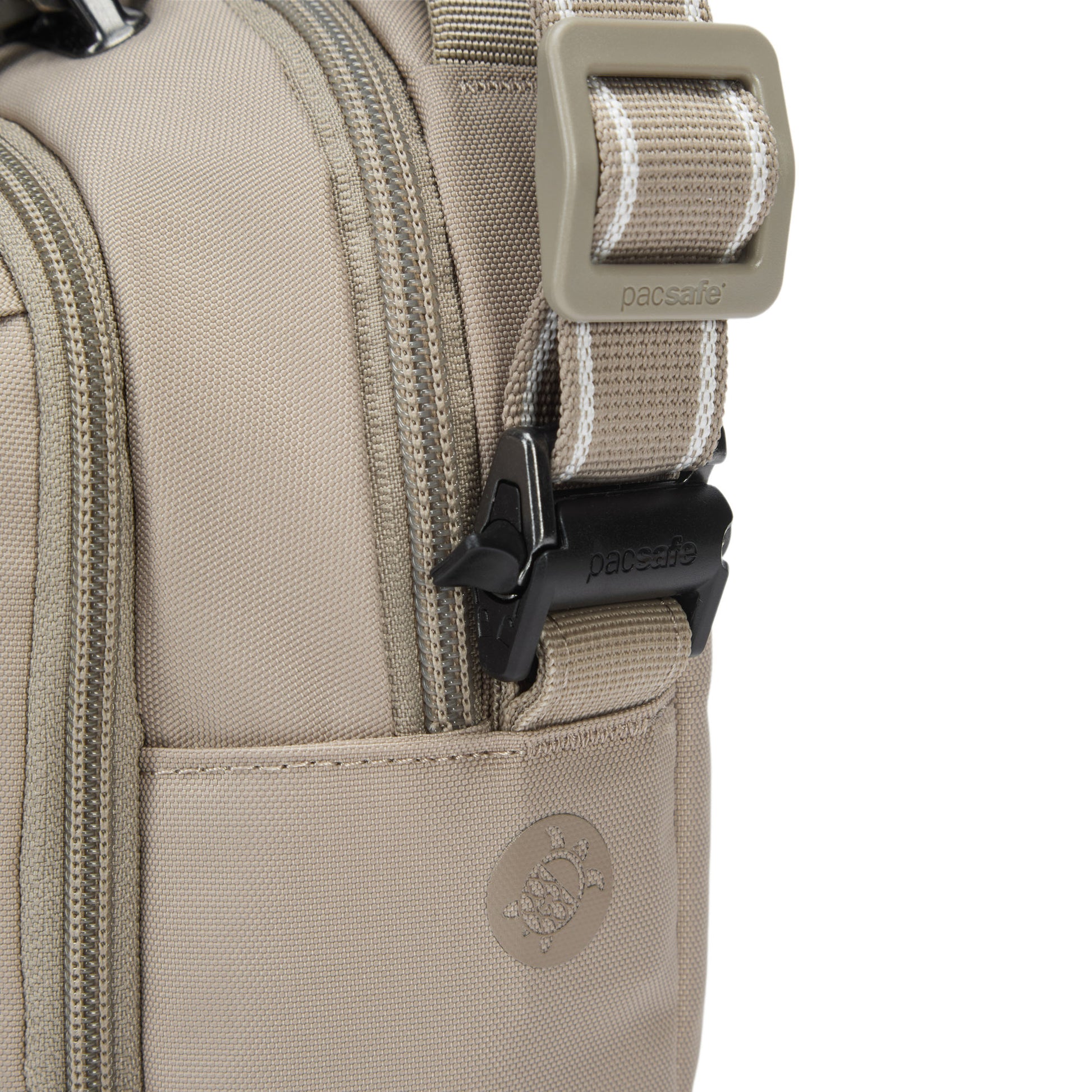 Close-up of Pacsafe® V Anti-theft Companion Crossbody bag in beige, showing zippers, buckle, and logo.