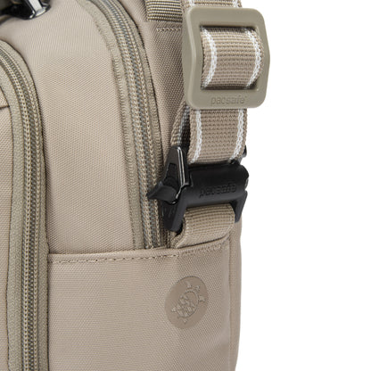 Close-up of Pacsafe® V Anti-theft Companion Crossbody bag in beige, showing zippers, buckle, and logo.