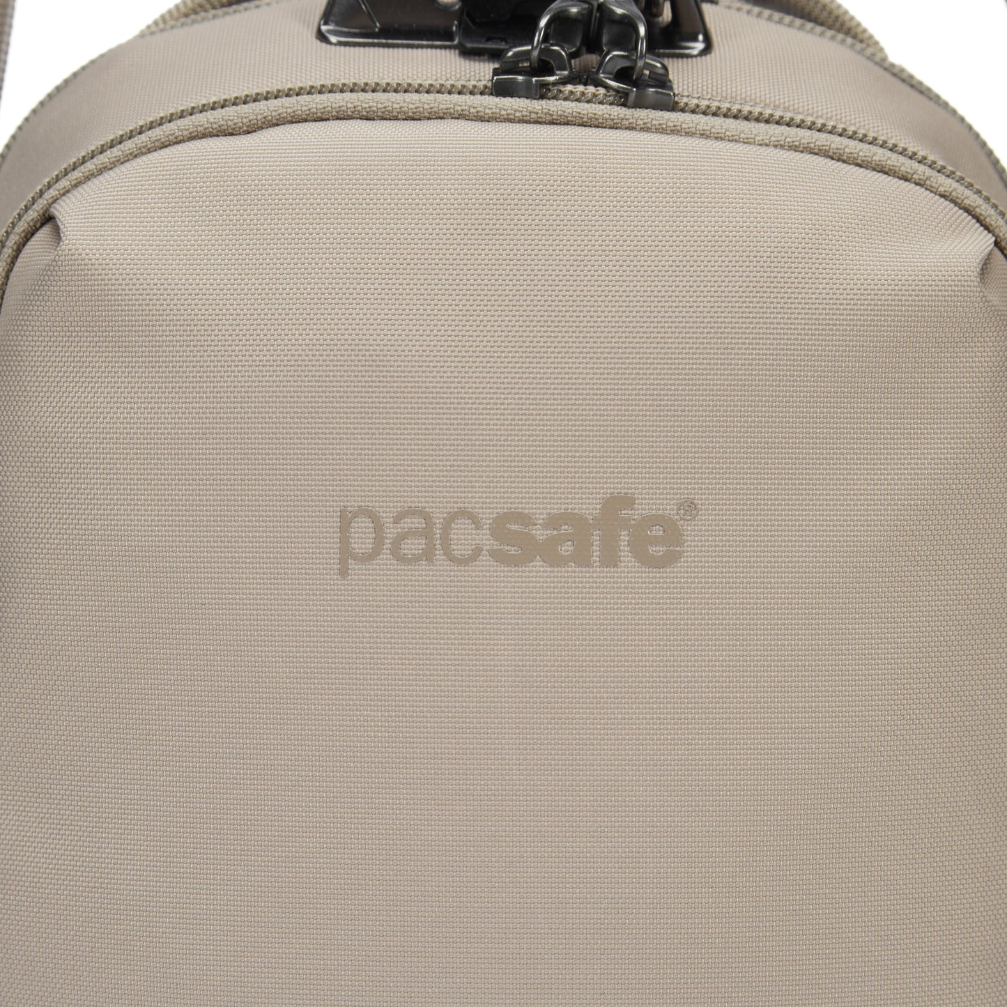 Close-up of the Pacsafe® V Anti-theft Companion Crossbody in beige, showing logo and top zipper.