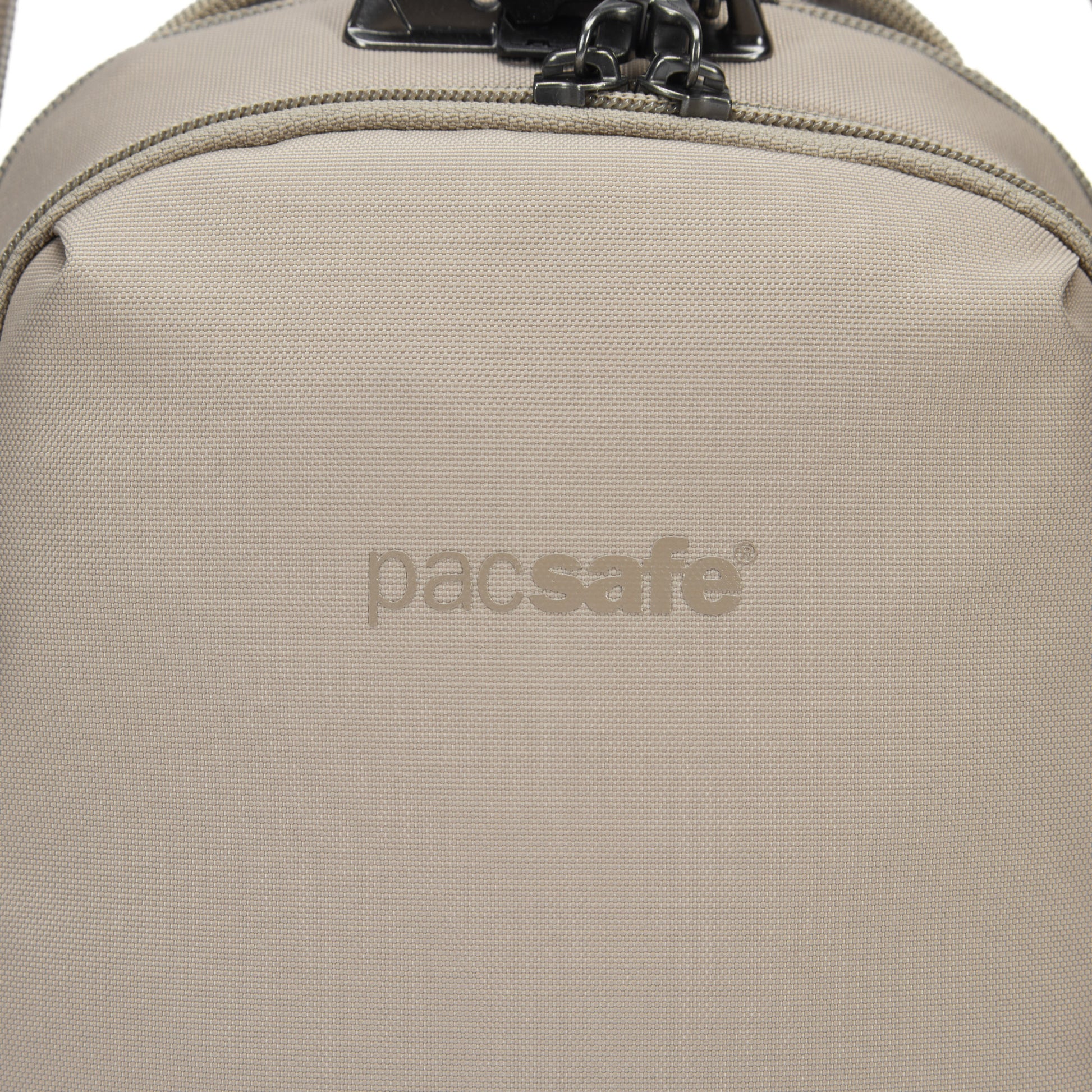 Close-up of the Pacsafe® V Anti-theft Companion Crossbody in beige, showing logo and top zipper.