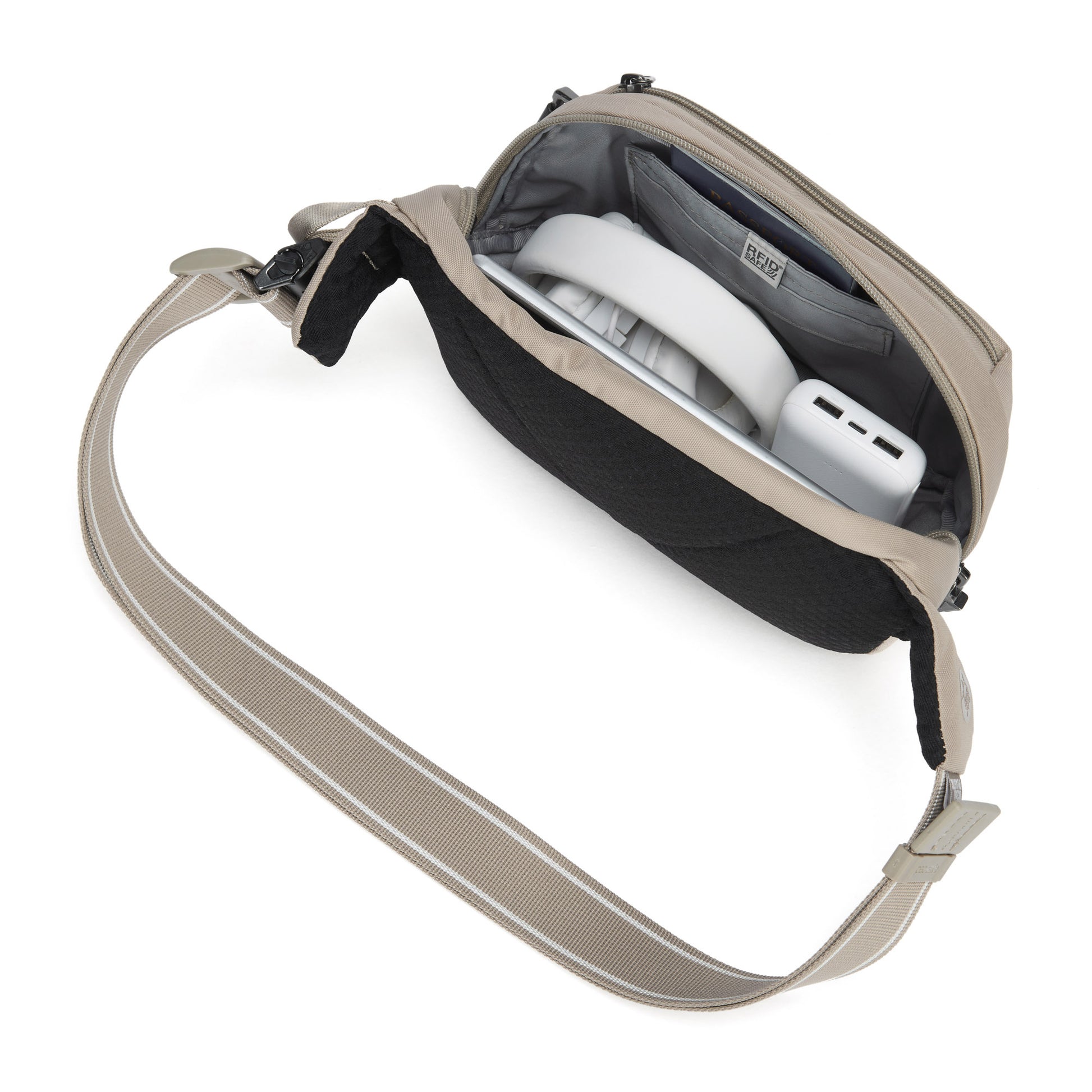 Pacsafe® V anti-theft hip pack in beige, top view with headphones and charger inside.