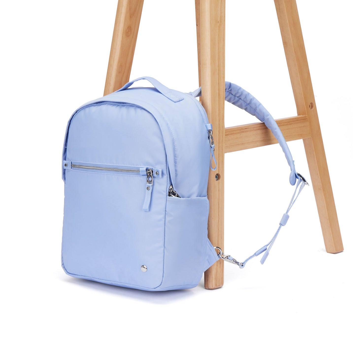 Pacsafe® W 10L Anti-theft Backpack in serenity blue with strap attached to chair leg.