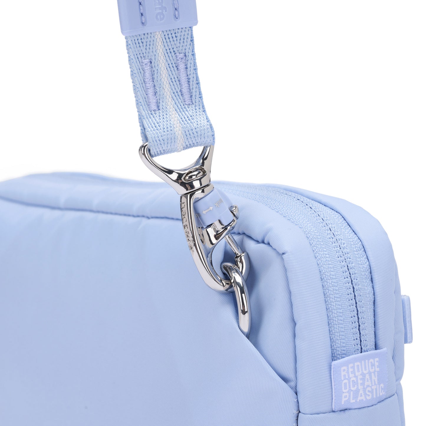 Close-up of the Pacsafe® W Anti-theft 3-in-1 Sling in light blue, with silver hardware and eco label.