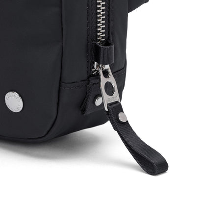 Close-up of Pacsafe® W Anti-theft Micro Sling’s metal zipper and pull tab, made from recycled polyester.
