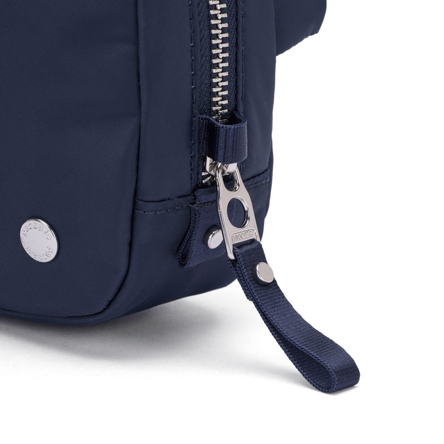Close-up of the Pacsafe® W Anti-theft Micro Sling in navy, featuring a metal zipper and branded snap button.