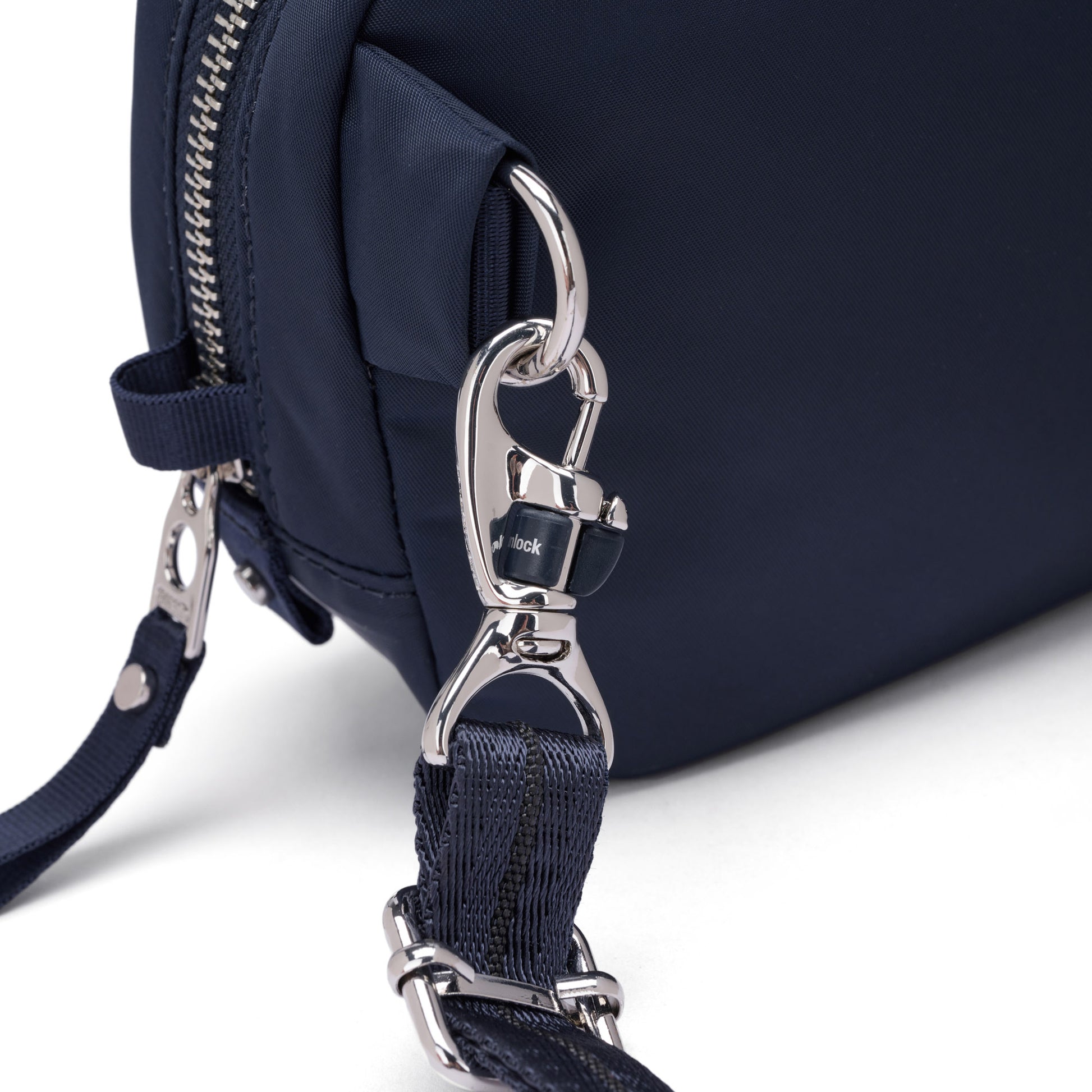 Close-up of the Pacsafe® W Anti-theft Micro Sling in navy, recycled polyester, with detachable strap and silver hardware.