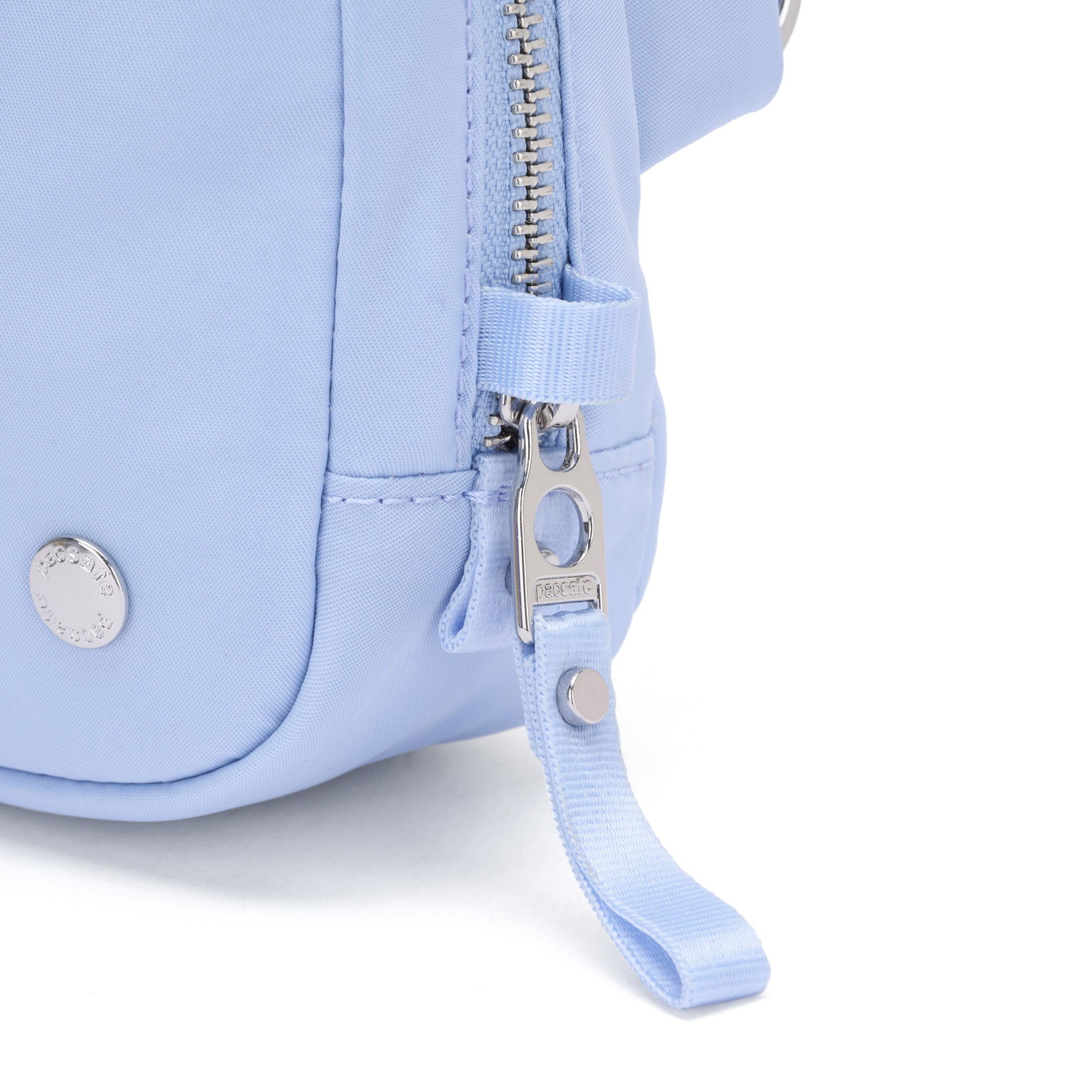 Close-up of the Pacsafe® W Anti-theft Micro Sling in light blue with silver zipper, button detail, and RFID blocking.