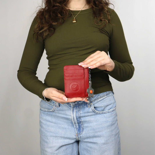 Product Image – Woman wearing jeans and green long sleeve shirt holding the red Espe Pastel Card Holder in front of her