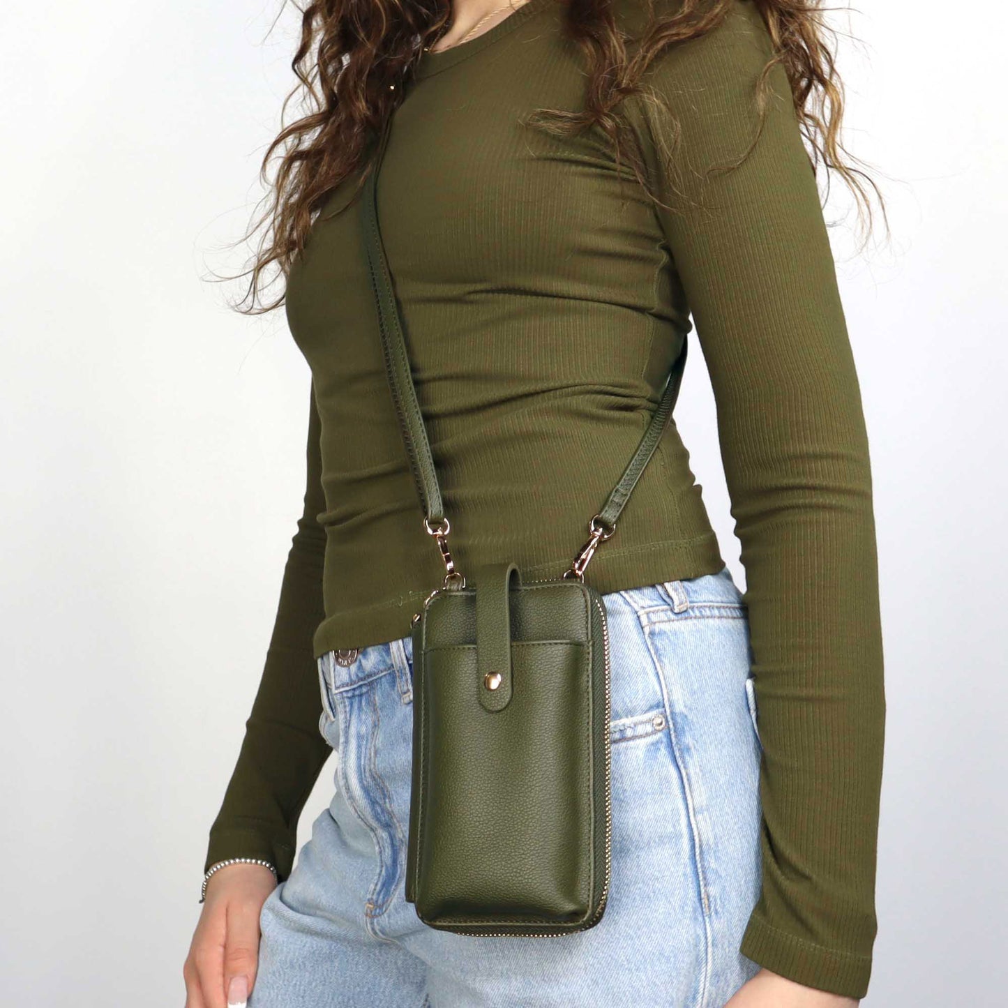 Woman wearing green long sleeve shirt and Espe Pastel Smartphone Pouch, moss green, front view