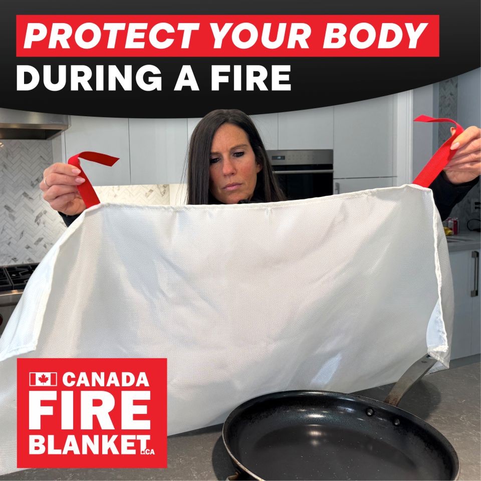 Woman with Canada Fire Blanket by stove; fire safety tips displayed behind frying pan.
