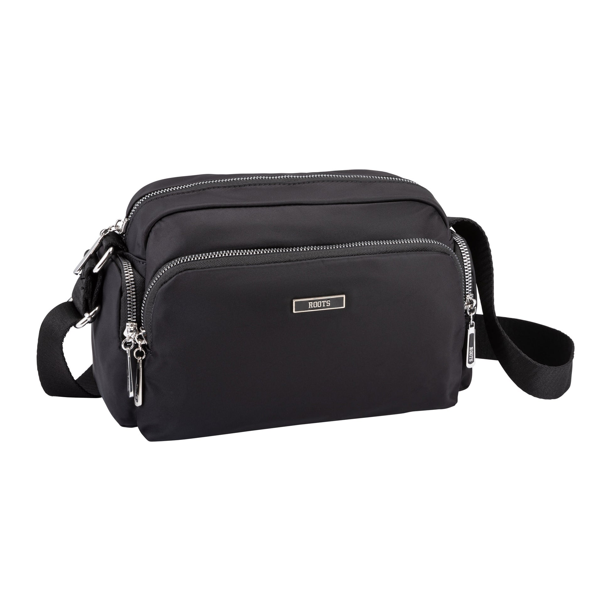 Black Roots Ally Camera Crossbody by Roots with pockets and adjustable strap, shown on a white background.