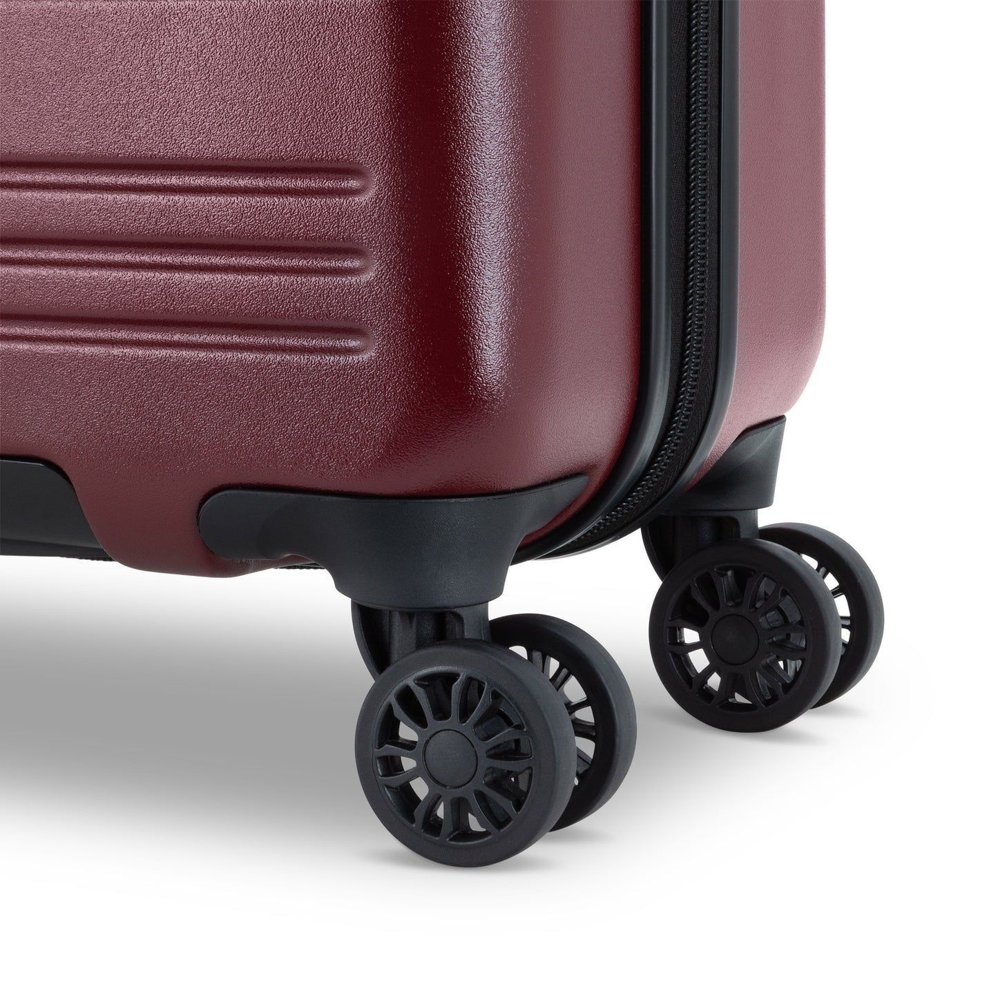 Close up of black spinner wheels on merlot red Roots Chalet Hardside Spinner Carry-on