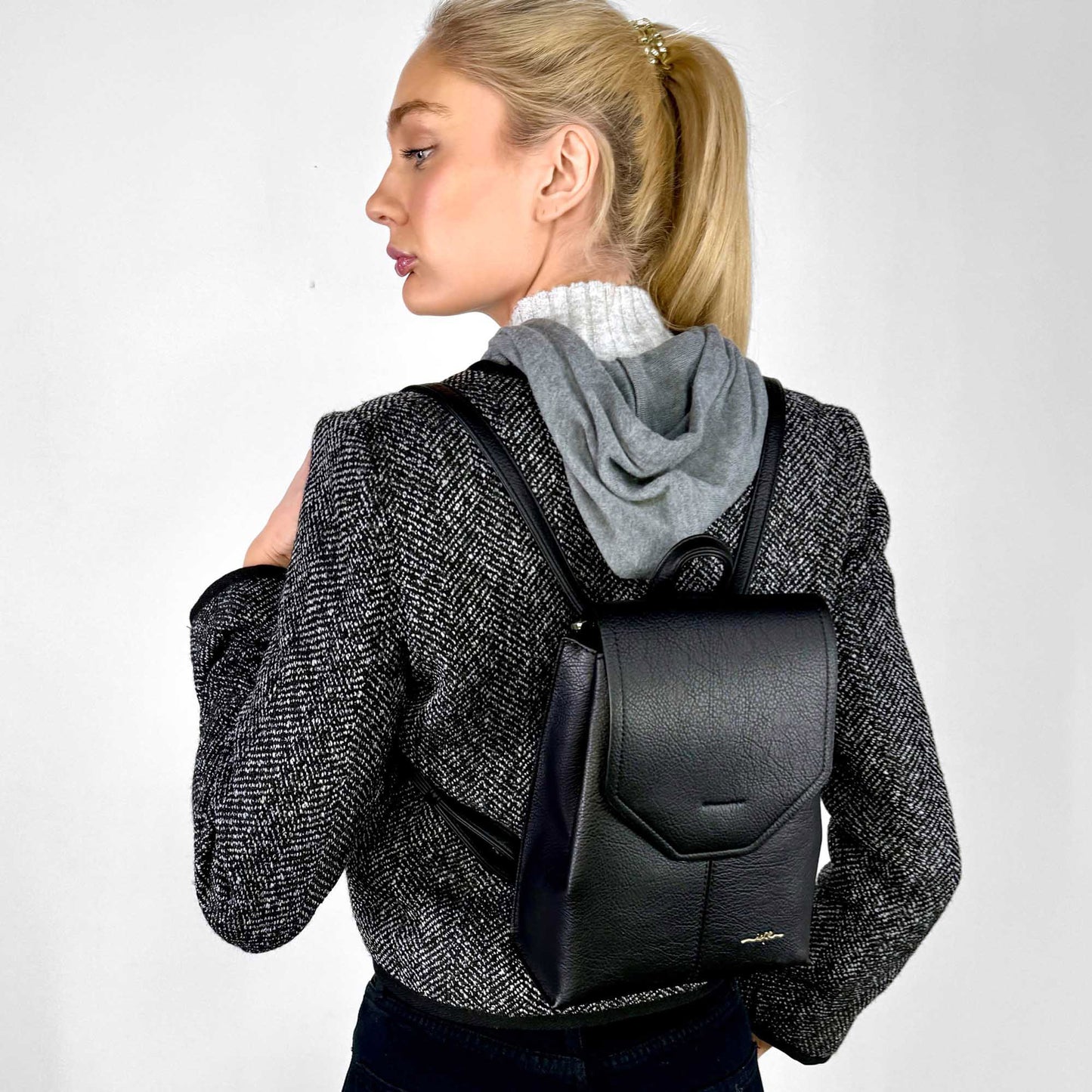 Back view of a woman wearing black houndstooth jacket and the black Espe Robson Backpack