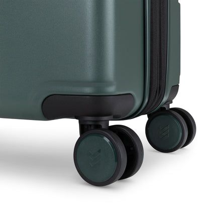 Close-up of two black and green spinner wheels on the Travelite Itinerary Large Expandable Hardside Spinner.