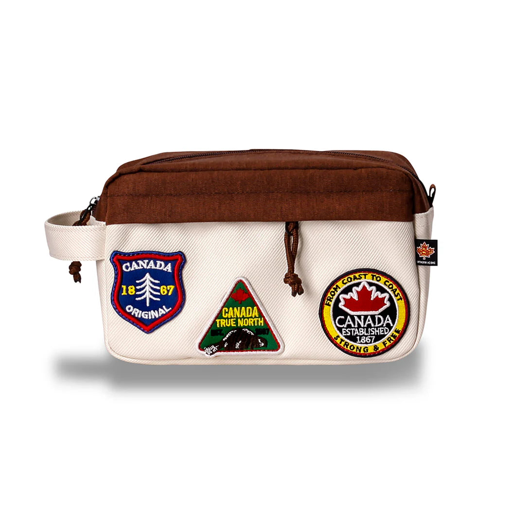 The Northern Icons Canada Travel Toiletry Bag is beige/brown with a handle and three embroidered patches.