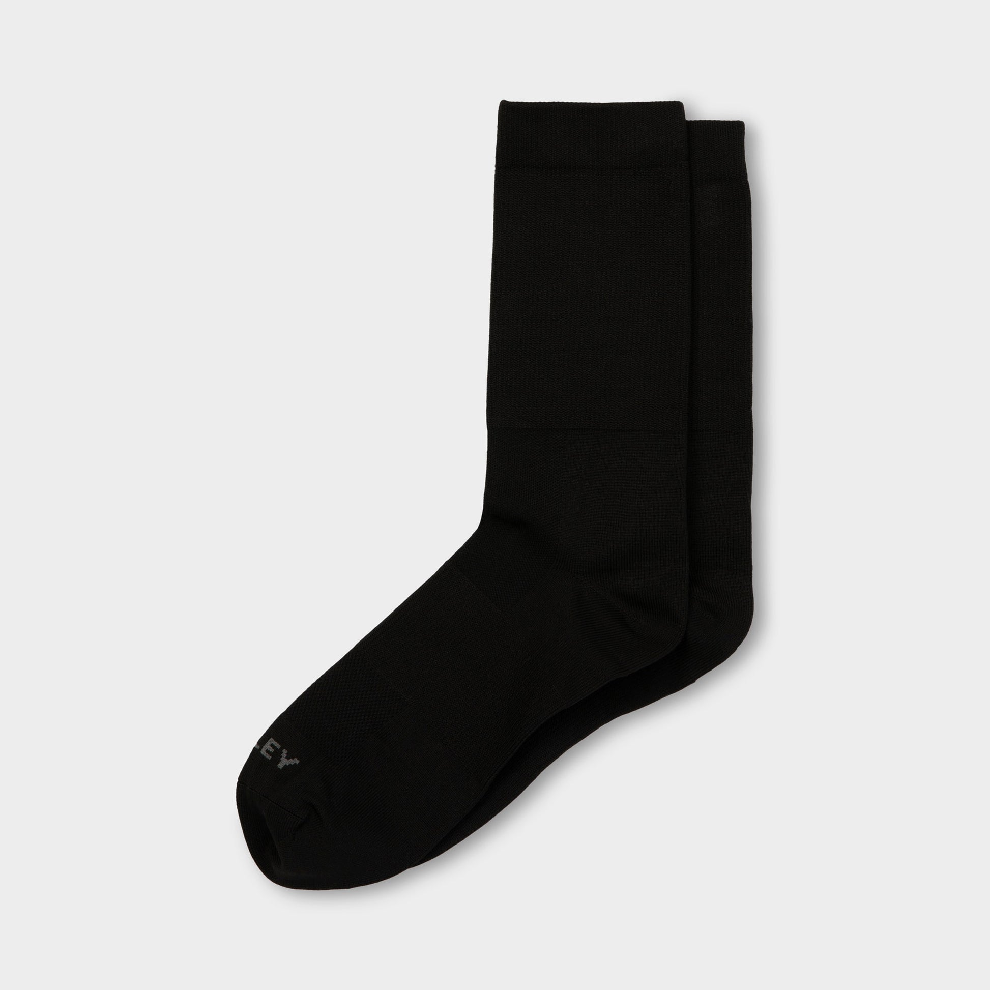 A pair of Tilley Mid Calf Travel Socks in black with arch support laid flat on a white background.