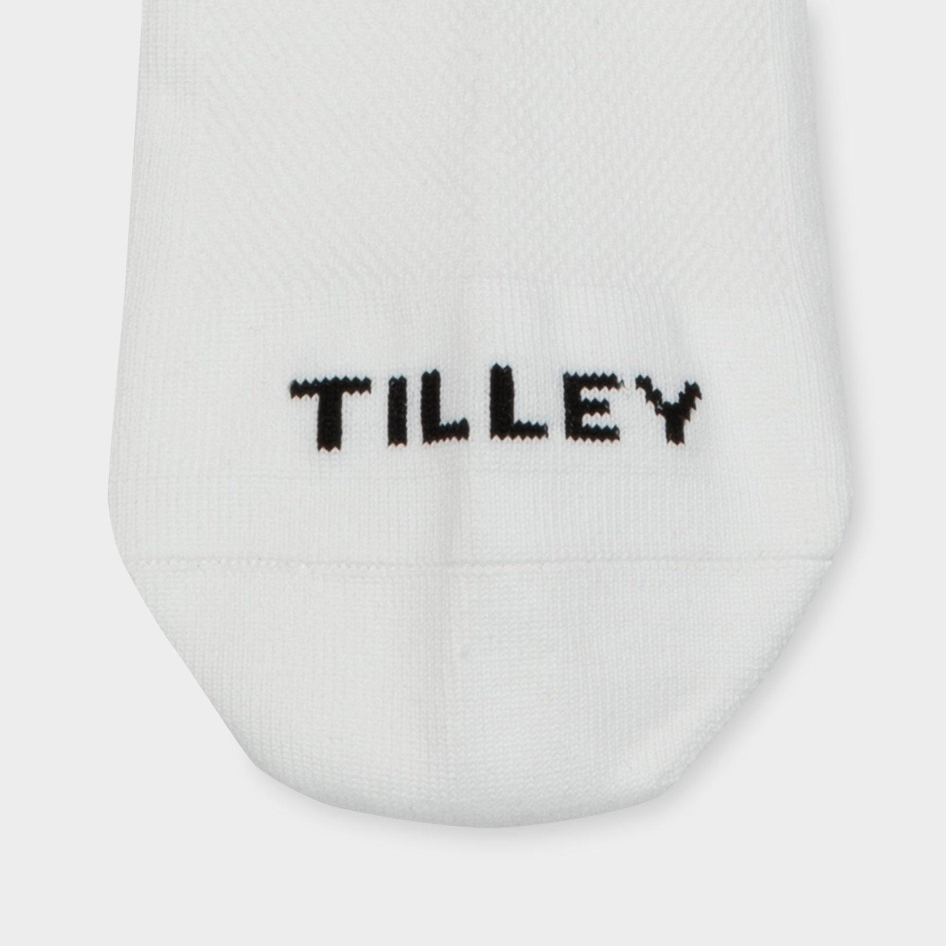 Tilley Ankle Travel Sock—white, moisture-wicking with "TILLEY" stitched in black near the toe.
