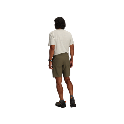 Man facing away in light tee, Royal Robbins Men's Wilder Short, black boots, watch; white background.