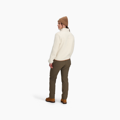 Person wearing a tan beanie, Royal Robbins Women's Palisades Jacket, olive pants, and brown shoes, facing backward.