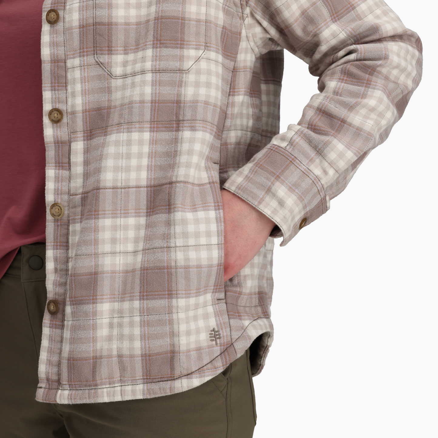 Woman wearing Royal Robbins Vista Flannel Shacket with maroon top and olive pants, hand in pocket.