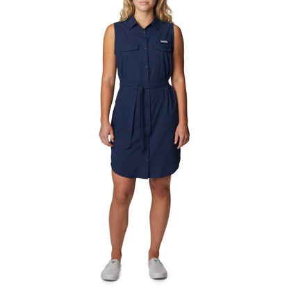 Woman wearing light grey running shoes and Columbia Women's PFG Sun Drifter™ Woven Dress II in collegiate navy, front view