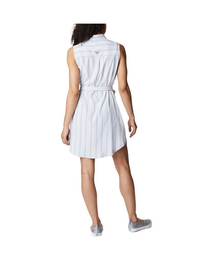 Woman wearing light grey running shoes and Columbia Women's PFG Sun Drifter™ Woven Dress II in carbon vertical stripe, back view